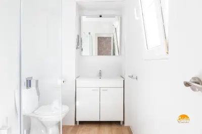 a white bathroom with a toilet and a sink at Mar de la Viña - Free Parking by Cádiz Time in Cádiz