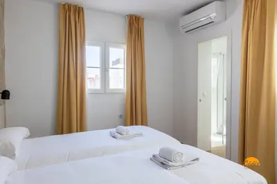 two white beds in a room with a mirror at Mar de la Viña - Free Parking by Cádiz Time in Cádiz