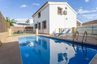 a swimming pool in front of a house at EntreCalas 3 chalet piscina privada Conil, Roche Viejo, Cala del Aceite in Conil de la Frontera