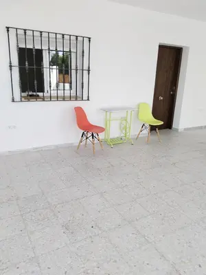 three chairs sitting next to a white wall at Casa EDU in Sanlúcar de Barrameda