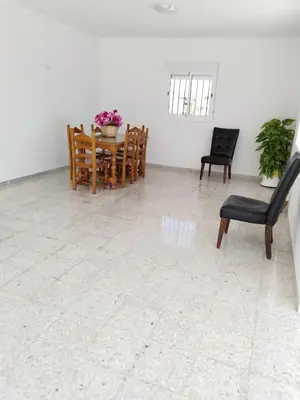 a room with chairs and a table with flowers on it at Casa EDU in Sanlúcar de Barrameda