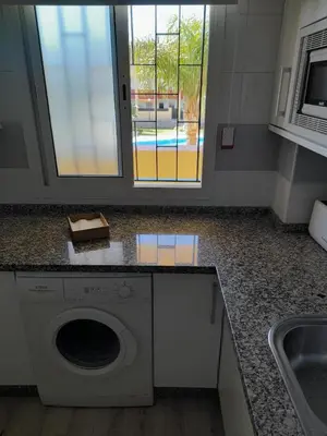 a kitchen with a washing machine and a sink at Apartamento Marisma del Guadalquivir in Sanlúcar de Barrameda