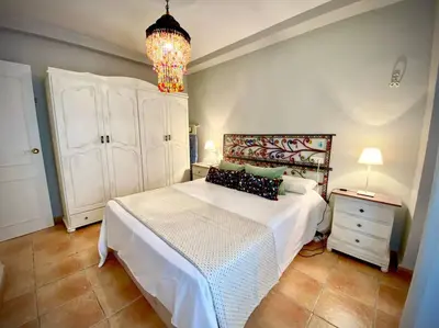 a bedroom with a white bed and a chandelier at MyChoice Marina in Rota