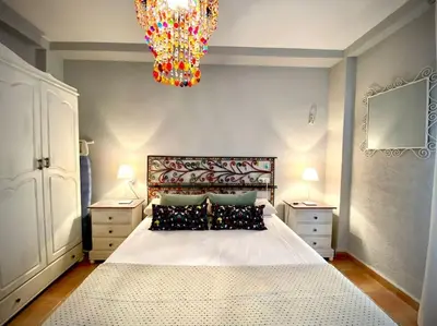 a bedroom with a large bed and a chandelier at MyChoice Marina in Rota