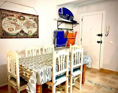 a dining room with a table with chairs and a clock at MyChoice Marina in Rota