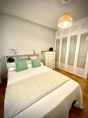 a bedroom with a large white bed with green pillows at MyChoice Marina in Rota