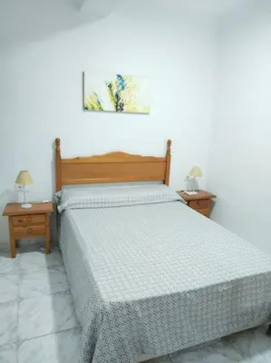 a bedroom with a bed and two night stands at Cozy Apartment in Chiclana City Center by Chiclana Dreams in Chiclana de la Frontera