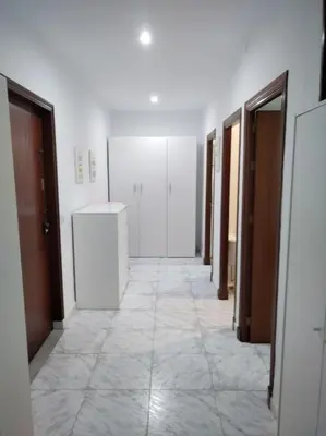a hallway of a room with doors and a tile floor at Cozy Apartment in Chiclana City Center by Chiclana Dreams in Chiclana de la Frontera