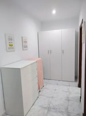 a white room with white cabinets and a counter at Cozy Apartment in Chiclana City Center by Chiclana Dreams in Chiclana de la Frontera