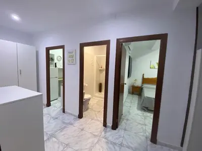 a room with three doors and a bathroom with a toilet at Cozy Apartment in Chiclana City Center by Chiclana Dreams in Chiclana de la Frontera