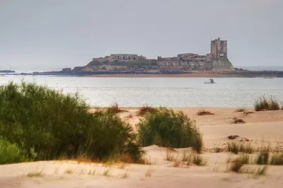 a view of a beach with a castle in the water at Cozy Apartment in Chiclana City Center by Chiclana Dreams in Chiclana de la Frontera