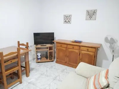 a living room with a couch and a tv at Cozy Apartment in Chiclana City Center by Chiclana Dreams in Chiclana de la Frontera