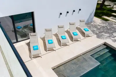 a row of chairs with computers on them next to a pool at ALBA SEA VILLA in Chiclana de la Frontera