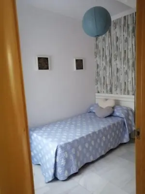 a bedroom with a bed and a blue lamp at Piso en San Fernando (Cádiz) in San Fernando