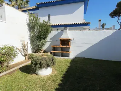 a backyard with a white fence and a white house at Quinta La Solana in Chiclana de la Frontera