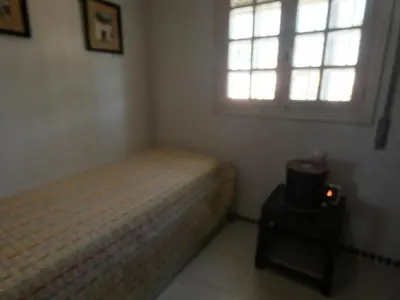 a small bedroom with a bed and a window at Quinta La Solana in Chiclana de la Frontera