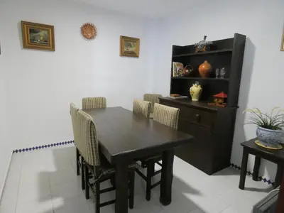 a dining room with a table and chairs and a shelf at Quinta La Solana in Chiclana de la Frontera