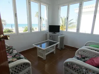 a room with four beds and a tv and windows at Quinta La Solana in Chiclana de la Frontera