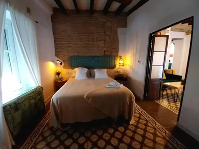a bedroom with a bed and a large window at Apartamento Boutique Kala Ático in Jerez de la Frontera