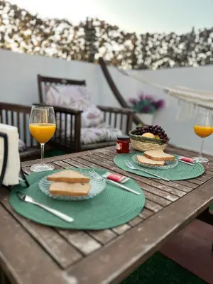 a table with two plates of sandwiches and glasses of orange juice at Apartamento Boutique Kala Ático in Jerez de la Frontera