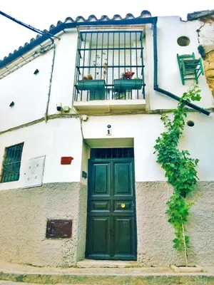 a green door on a white building with a balcony at Apartamento Boutique Kala Ático in Jerez de la Frontera