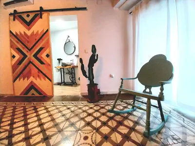 a room with a chair and a painting on the wall at Apartamento Boutique Kala Ático in Jerez de la Frontera