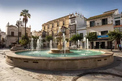 a fountain in the middle of a street with buildings at El piso de Manuel in Sanlúcar de Barrameda