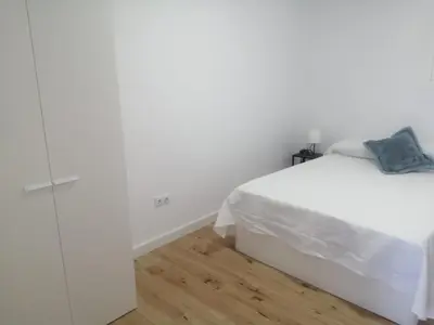a bedroom with a white bed and a wooden floor at 3 bedroom Apartment in San Fernando in San Fernando