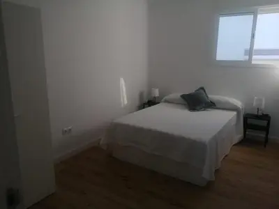 a white bedroom with a bed and a window at 3 bedroom Apartment in San Fernando in San Fernando
