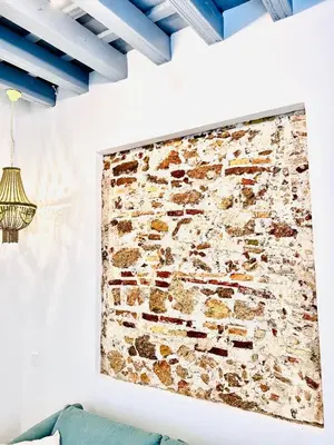 a brick wall in a living room with a painting on the wall at inncadiz Casa Los Balbos in Cádiz