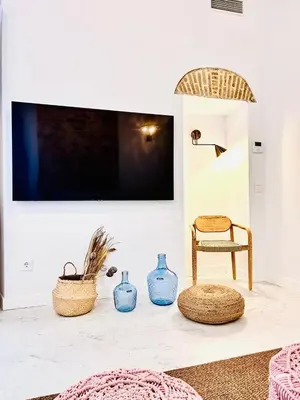 a living room with vases and a tv on a wall at inncadiz Casa Los Balbos in Cádiz