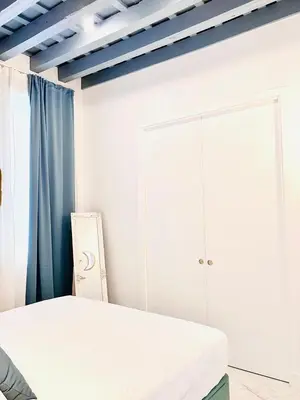 a white bedroom with a bed and a cabinet at inncadiz Casa Los Balbos in Cádiz