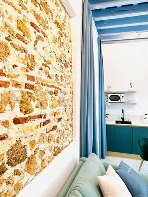 a living room with a brick wall and a couch at inncadiz Casa Los Balbos in Cádiz