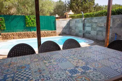 a table and chairs next to a swimming pool at Casa Caramelo in Medina Sidonia
