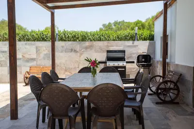 a table and chairs on a patio with a grill at Casa Caramelo in Medina Sidonia