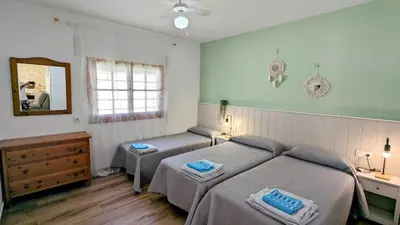 a bedroom with two beds and a mirror at Conil fuente del gallo in Conil de la Frontera
