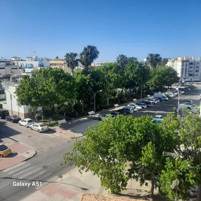 a city street with cars parked in a parking lot at Casa juani in Rota