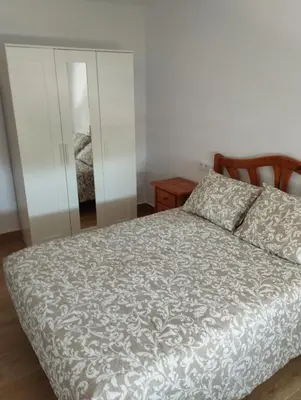 a bedroom with a bed and a mirror at Casa juani in Rota