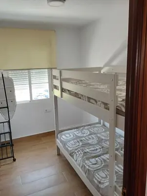 a kitchen with white cabinets and a table in it at Casa juani in Rota