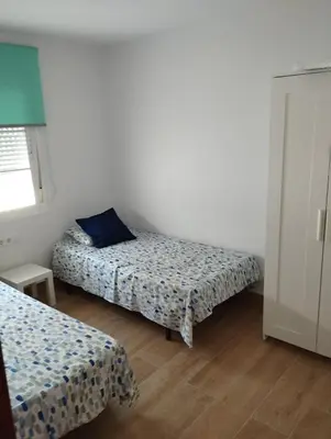 a bedroom with two beds and a window at Casa juani in Rota