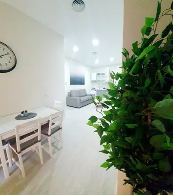 a living room with a table and a plant at Apartamento Plaza Calzada 2 in Sanlúcar de Barrameda