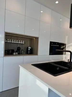 a kitchen with a black sink and white cabinets at VILLA MARIAH Barrosa Playa in Novo Sancti Petri