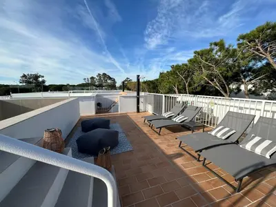 a deck with lounge chairs on a balcony at VILLA MARIAH Barrosa Playa in Novo Sancti Petri