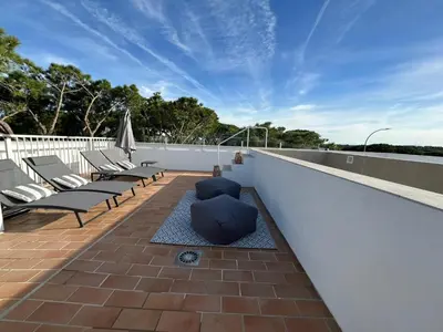a rooftop patio with lounge chairs and a blue sky at VILLA MARIAH Barrosa Playa in Novo Sancti Petri