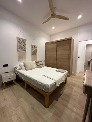 a bedroom with a large bed and a ceiling fan at VILLA MARIAH Barrosa Playa in Novo Sancti Petri