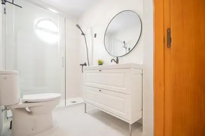 a white bathroom with a toilet and a mirror at El Rosal de Huertas in Cádiz