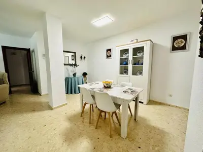 a dining room with a white table and chairs at Avenida Portugal con Ascensor Grupo AC Gestión in Cádiz