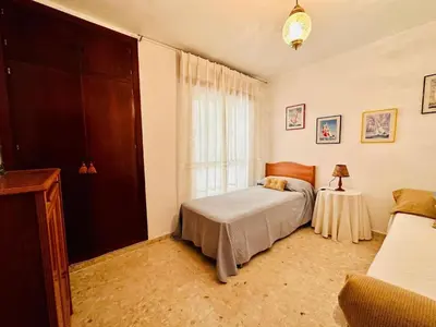 a bedroom with a bed and a table and a window at Avenida Portugal con Ascensor Grupo AC Gestión in Cádiz