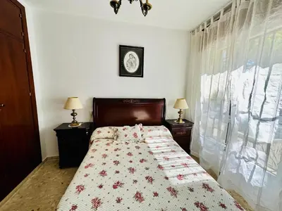 a bedroom with a bed with a quilt on it at Avenida Portugal con Ascensor Grupo AC Gestión in Cádiz