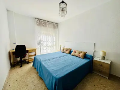 a bedroom with a blue bed with a desk and a chair at Avenida Portugal con Ascensor Grupo AC Gestión in Cádiz